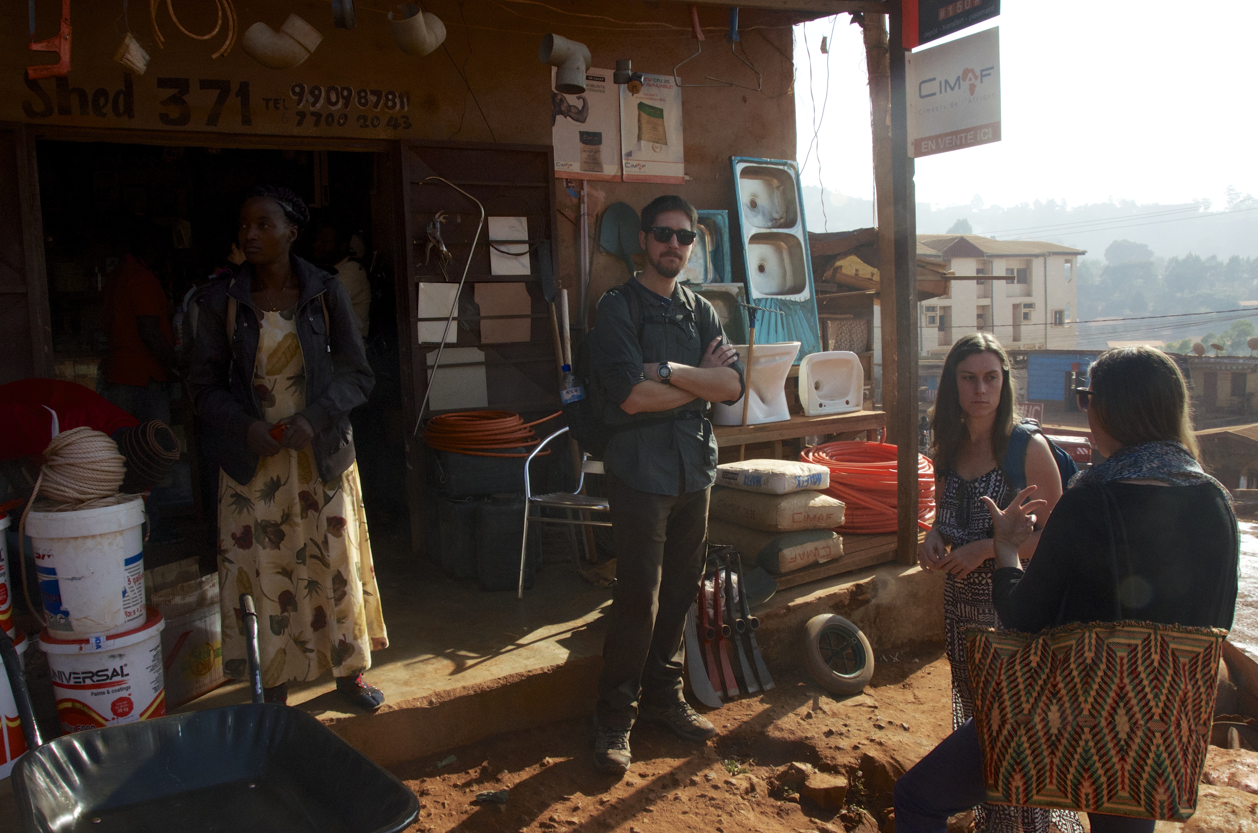 Garrett, Kathy, Cait, and Maxeline (our local cook) wait while we buy building materials in Kumbo